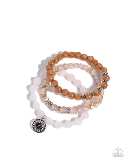 Set of beaded bracelets with a central charm on a white background