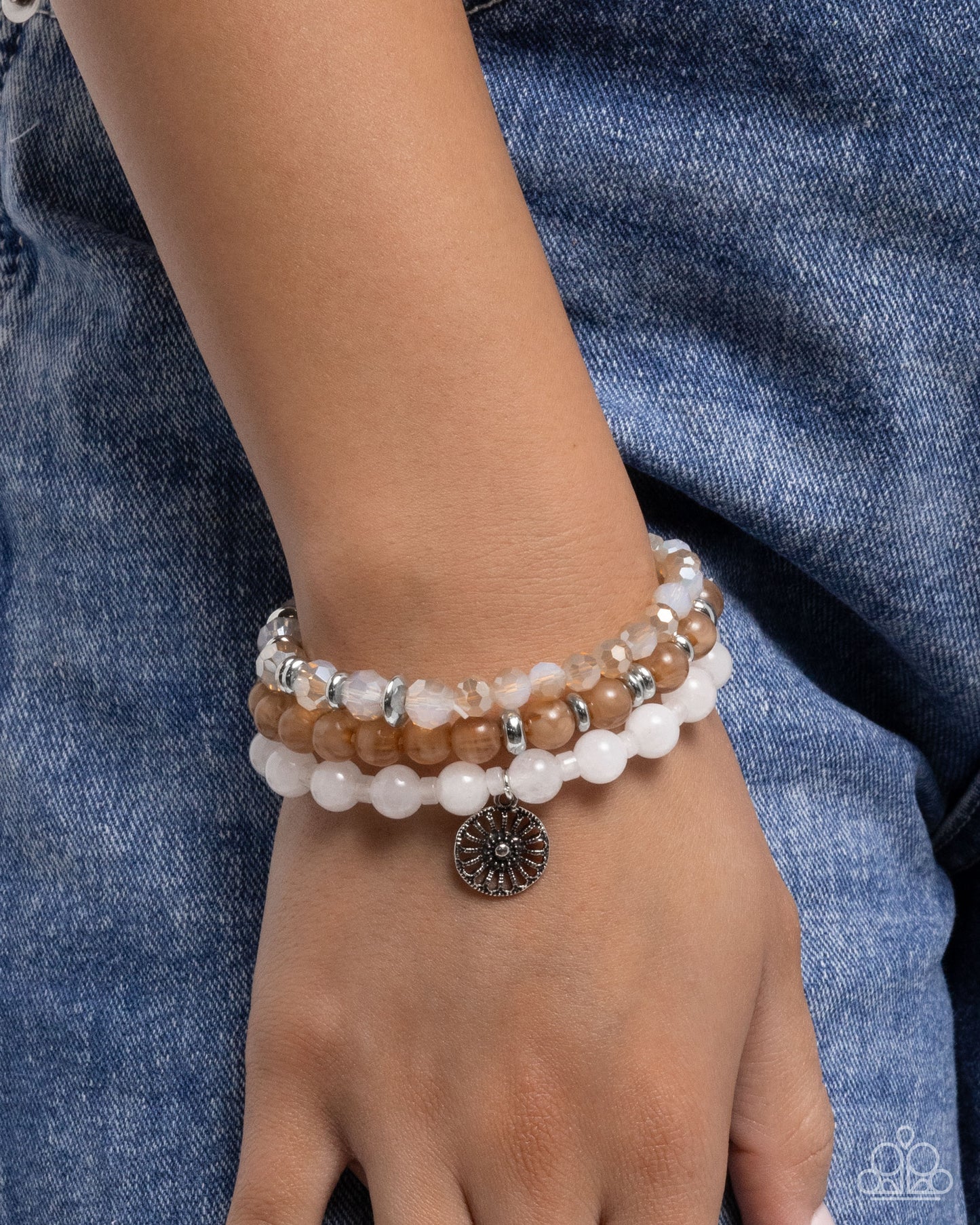 Stack of beaded bracelets on a wrist with a denim background