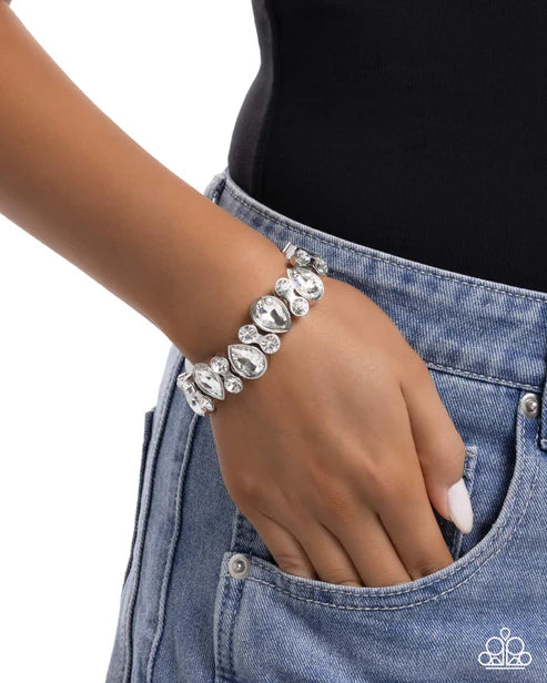 Silver bracelet on a wrist with a denim background