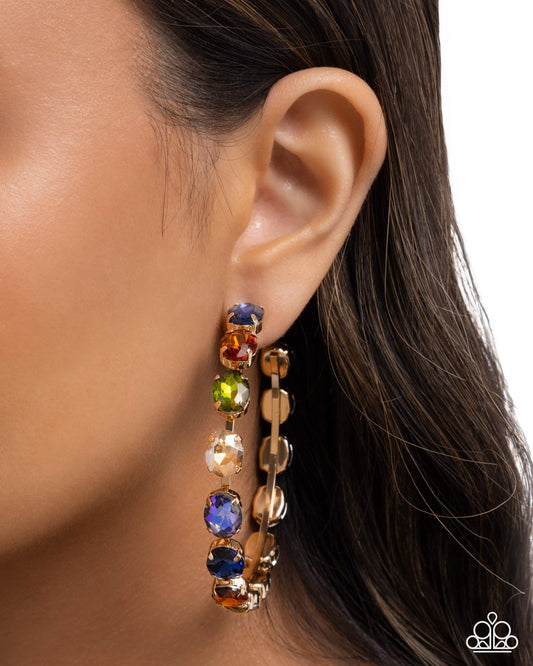 Multicolored gemstone earring worn by a person with dark hair.