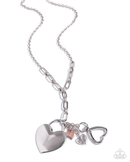 Silver necklace with heart-shaped charms on a white background