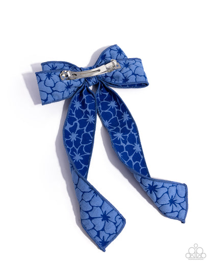 Blue floral patterned hair bow with a silver clip on a white background