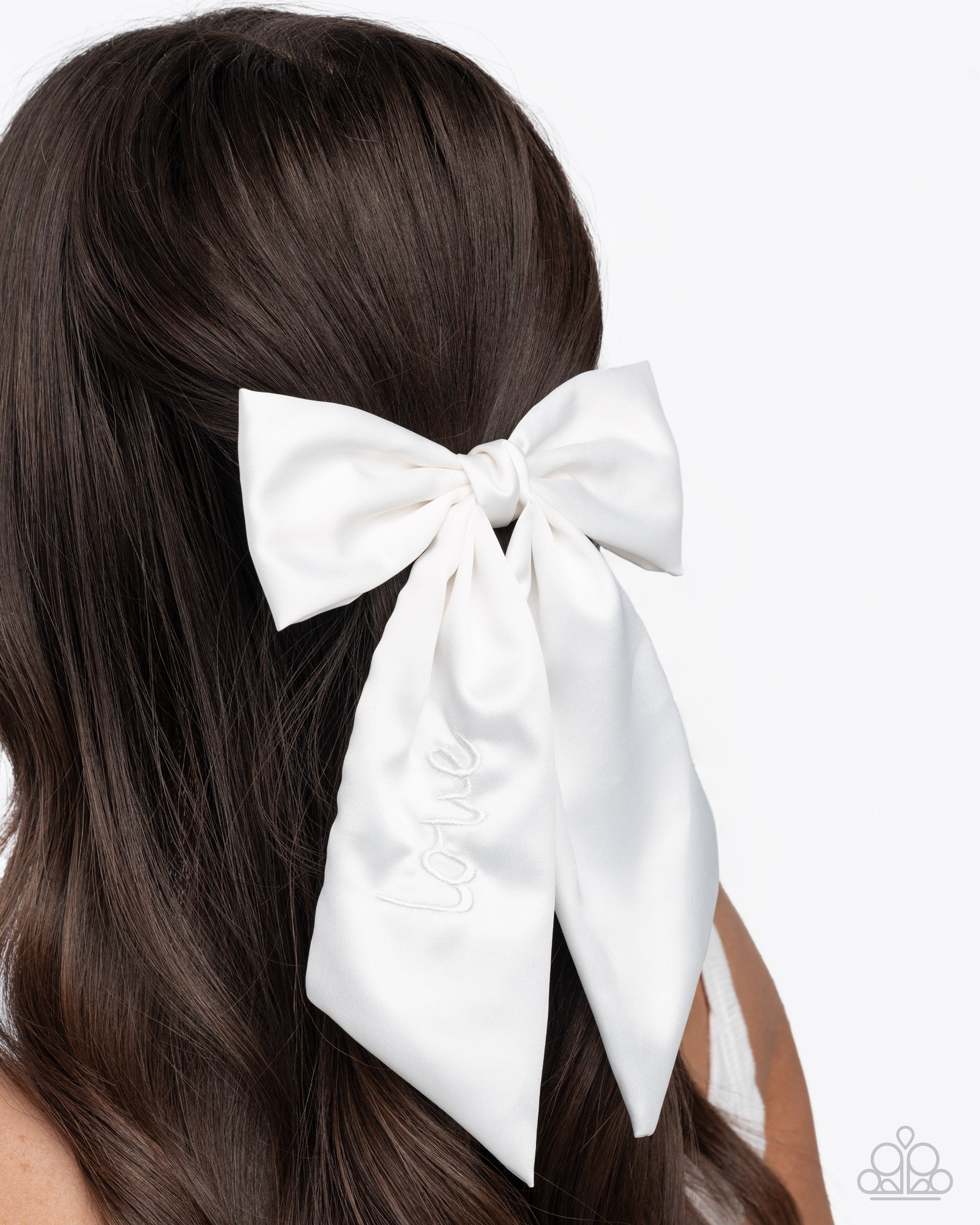 White hair bow on a person with brown hair against a white background