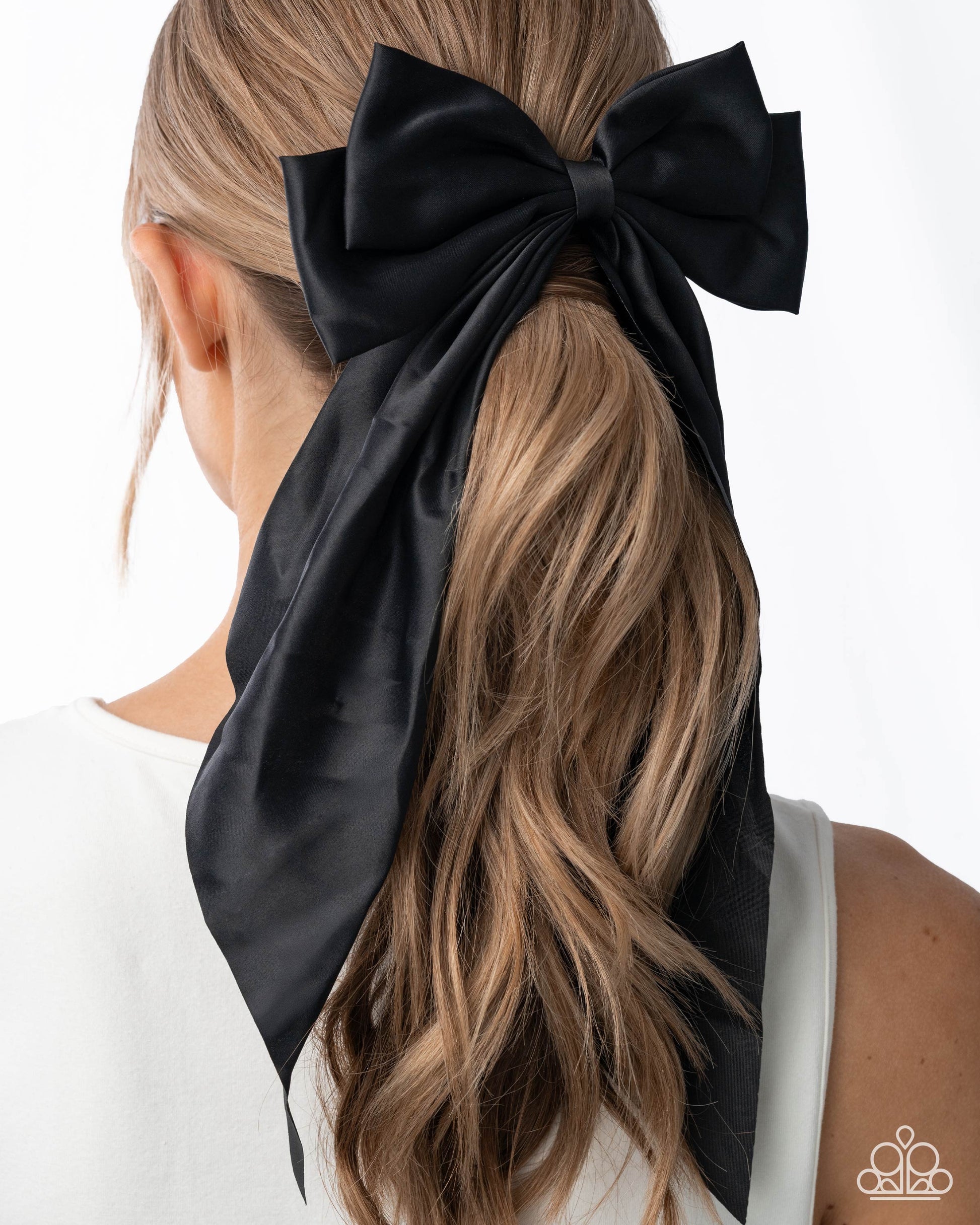 Black hair bow tied in a ponytail with a white background