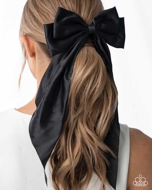 Black hair bow tied in a ponytail with a white background