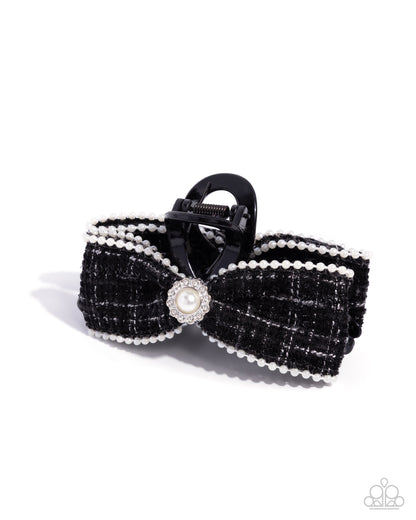 Black bow hair clip with pearl accents on a white background