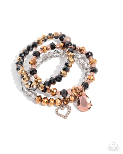 Set of beaded bracelets with rose gold accents on a white background