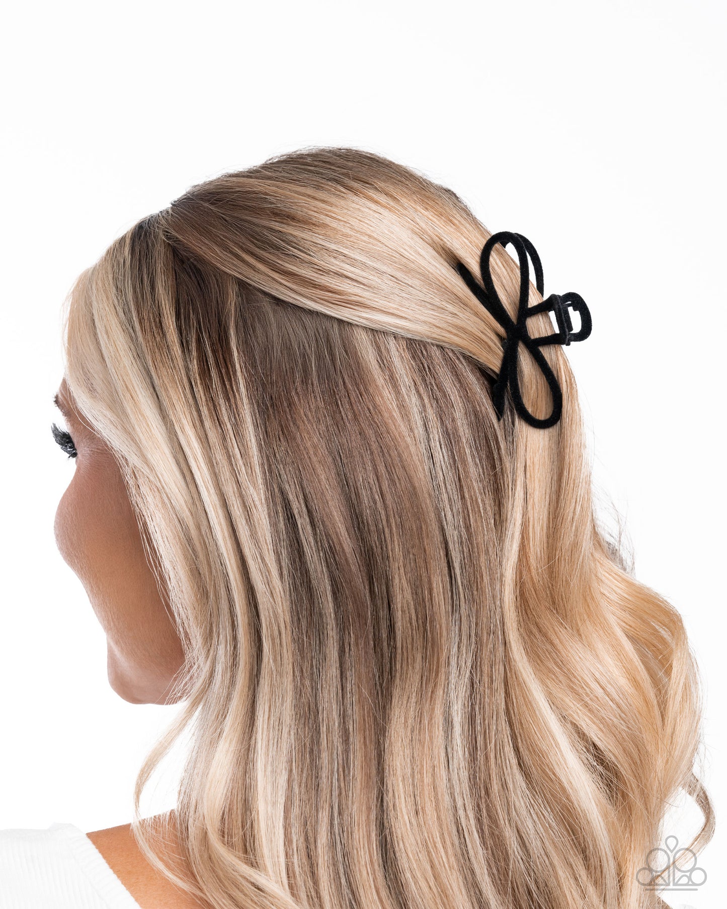 Black butterfly hair clip on a person with blonde hair against a white background
