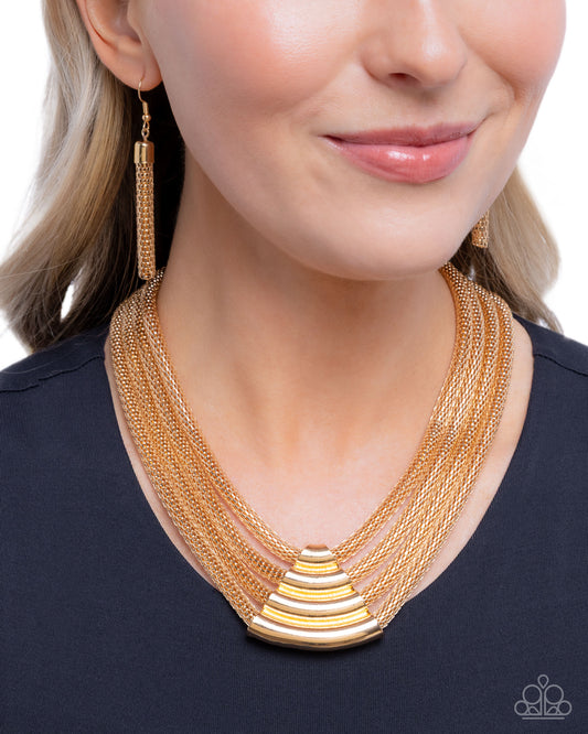 Woman wearing a gold necklace and earrings on a white background