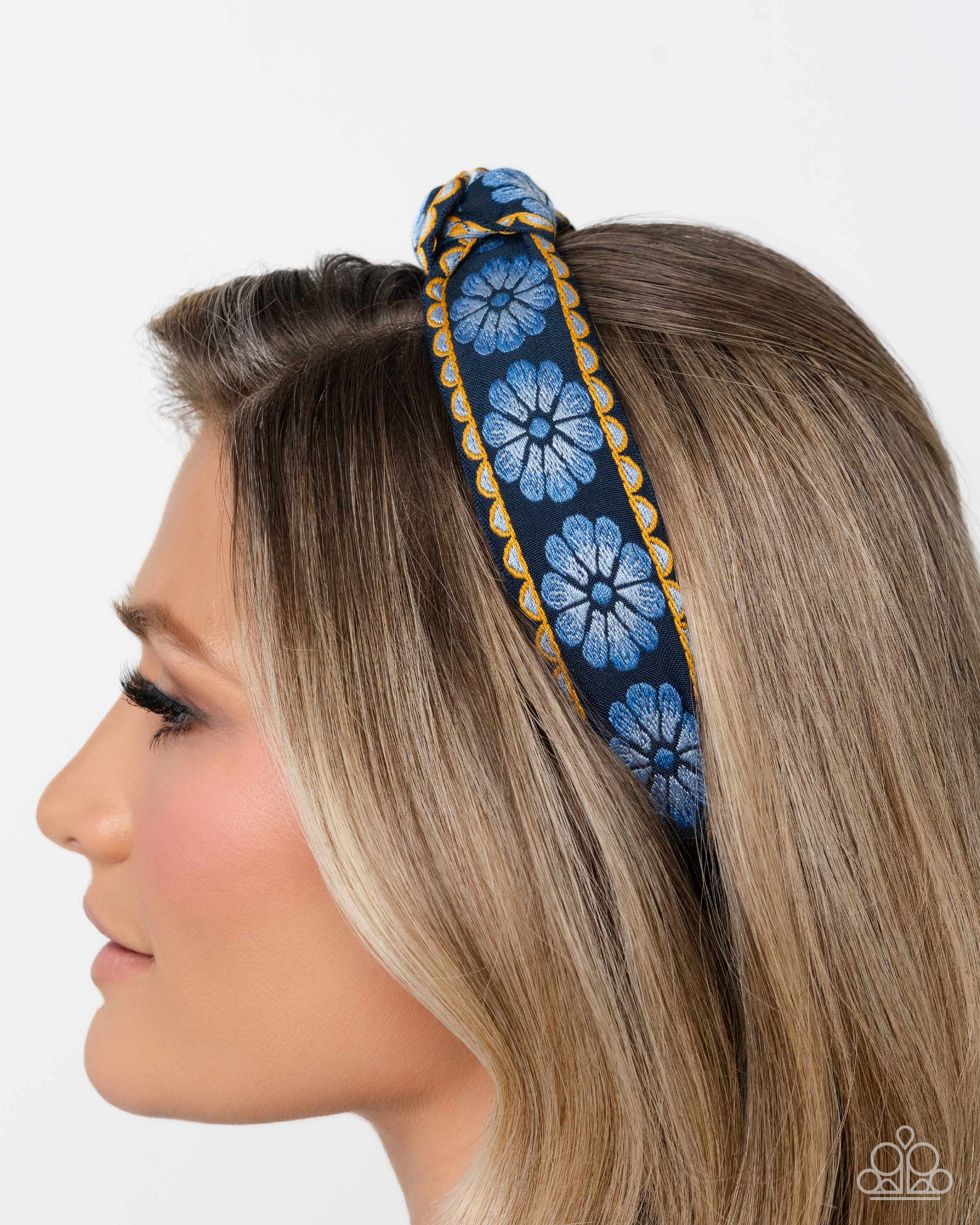 Woman wearing a blue floral headband on a white background