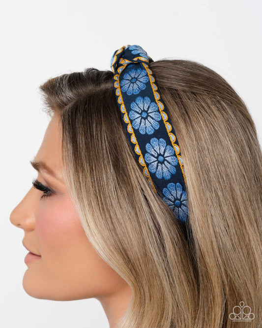 Woman wearing a blue floral headband on a white background