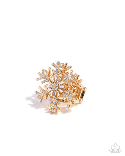 Gold and silver snowflake-shaped brooch on a white background