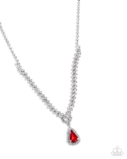 A silver-toned beaded necklace with a teardrop-shaped pendant featuring a bright red gemstone surrounded by small clear stones, shown on a plain white background.