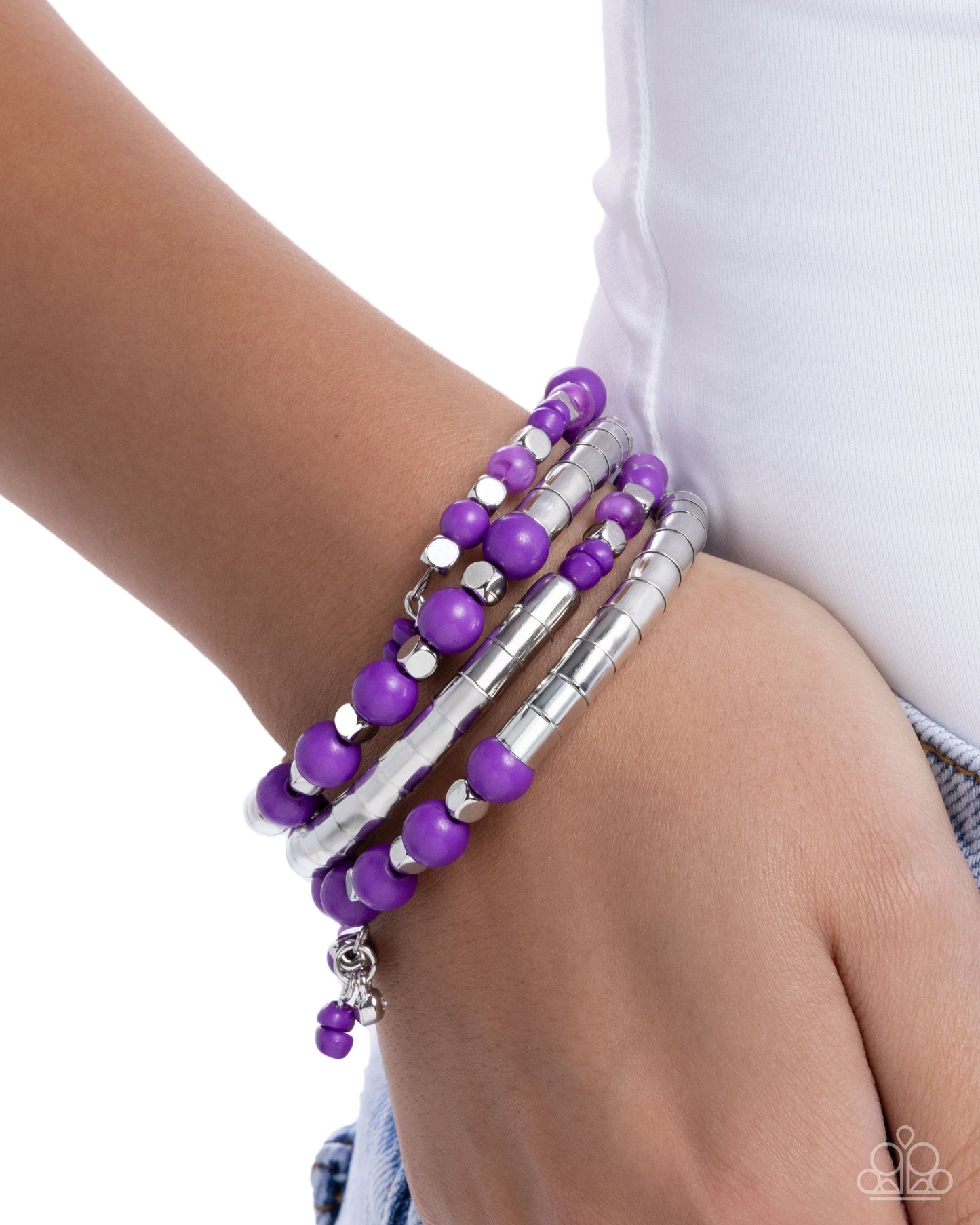 Purple beaded bracelet on a wrist with a white background