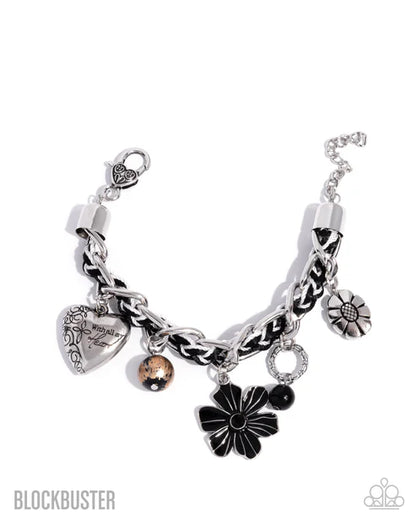 Silver bracelet with various charms on a white background