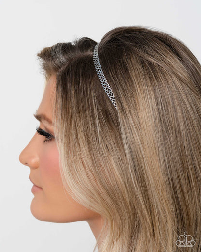 Woman wearing a silver headband with a white background