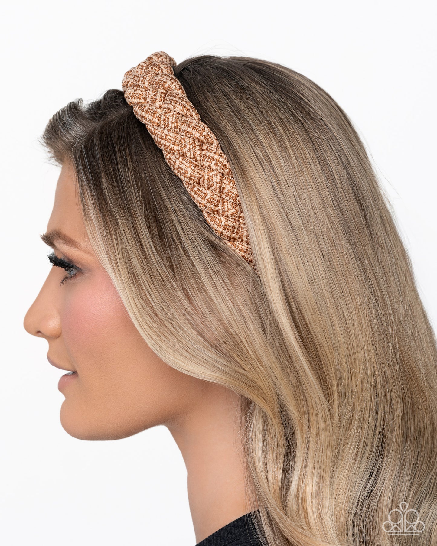 Woman wearing a rose gold knotted headband on a white background