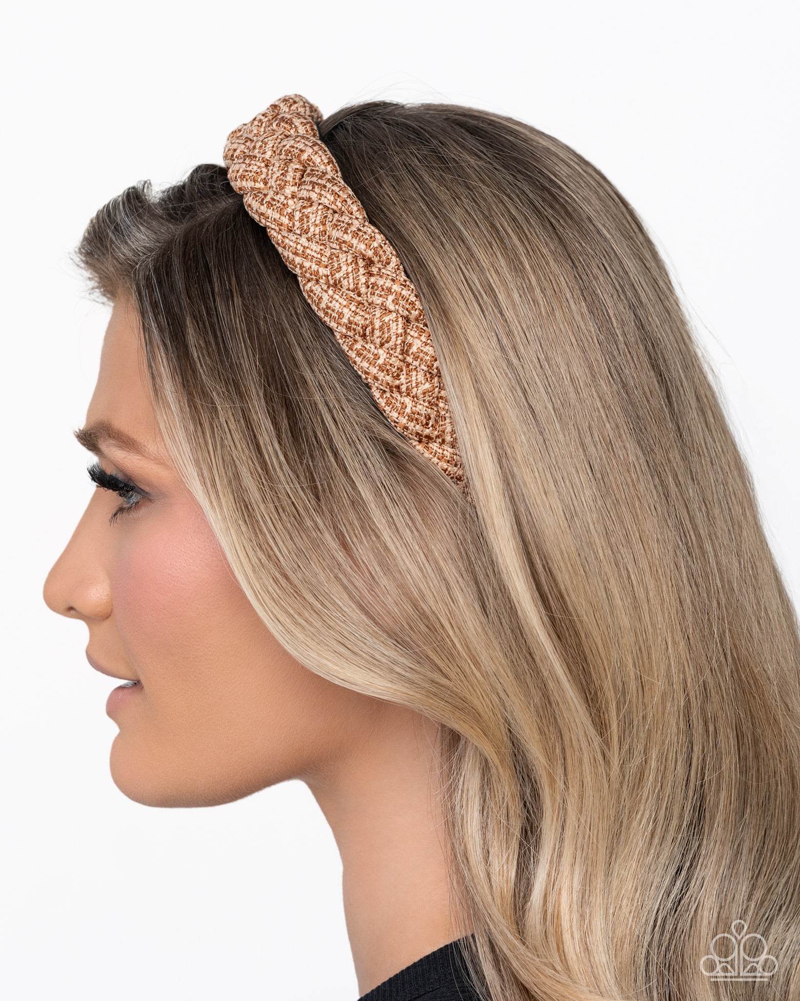 Woman wearing a rose gold knotted headband on a white background