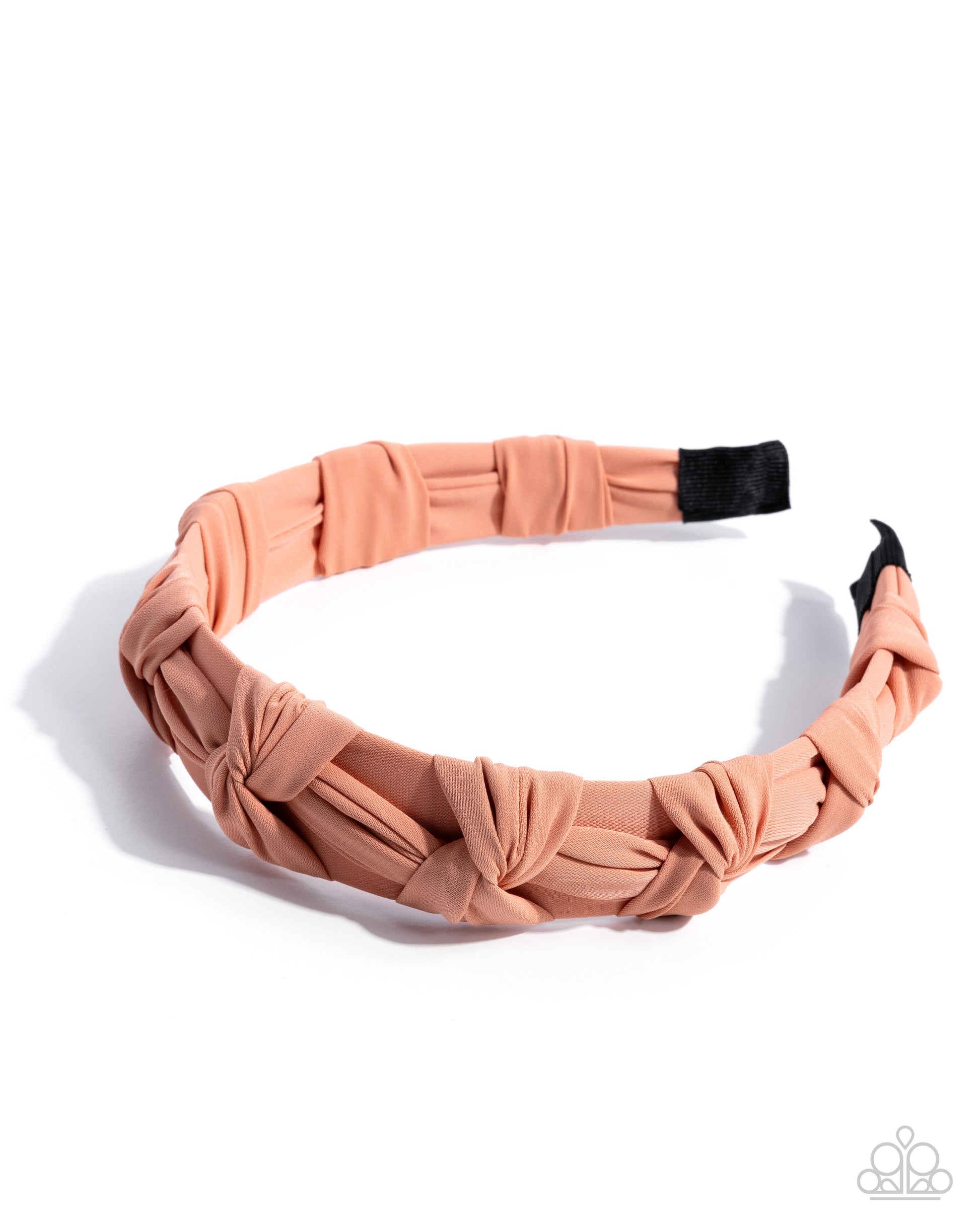Pink knotted headband on a white background