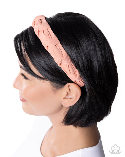 Woman wearing a pink woven headband on a white background