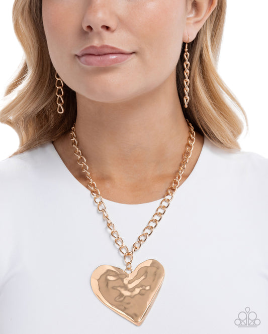 Rose gold chain necklace with a heart-shaped pendant worn by a model on a white background