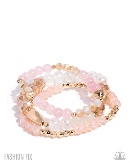 Stack of pink and gold beaded bracelets on a white background