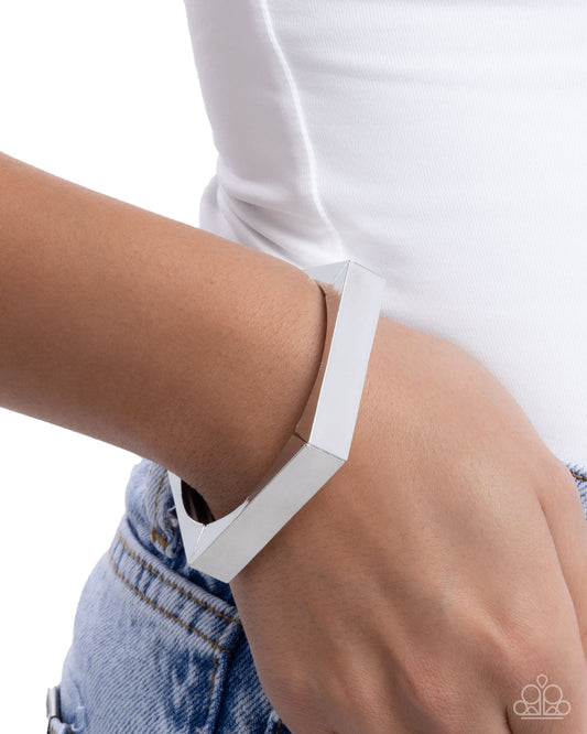 White bracelet on a wrist with a white shirt and blue jeans