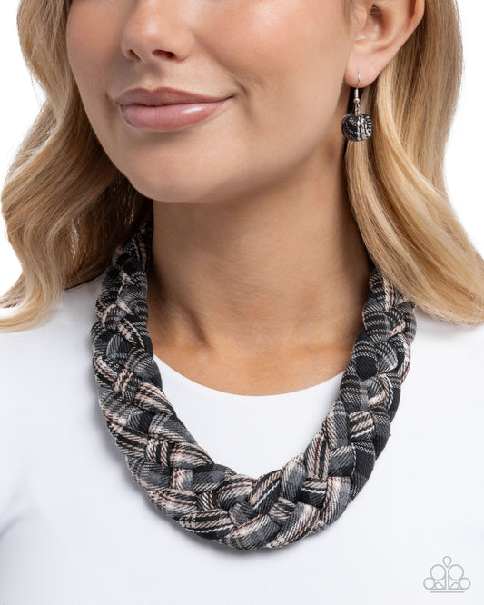Woman wearing a braided necklace and earrings on a white background