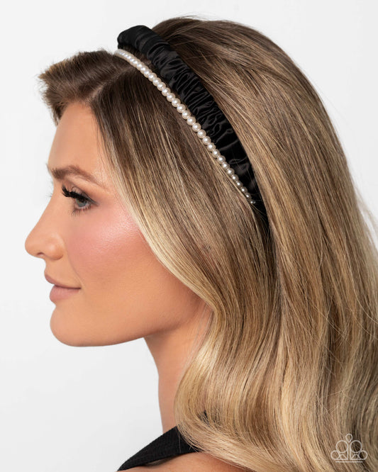 Woman wearing a black headband with pearls on a white background