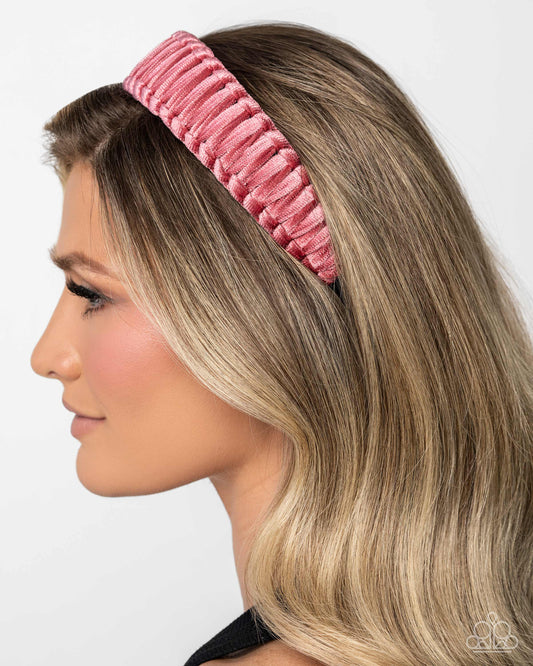 Woman wearing a pink headband against a white background