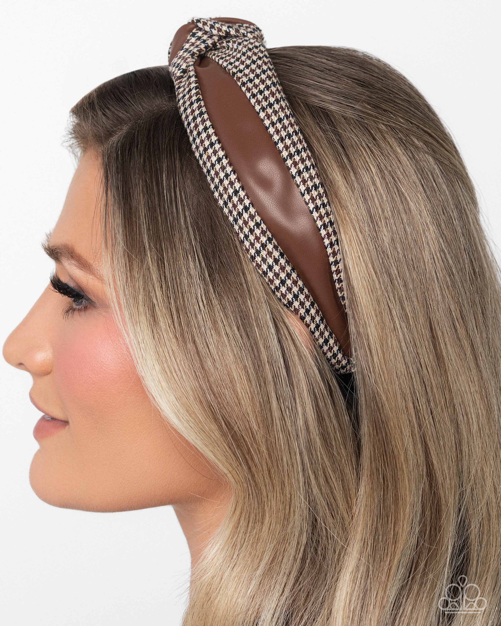 Woman wearing a houndstooth patterned headband on a white background