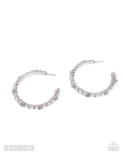 Silver hoop earrings with small stones on a white background