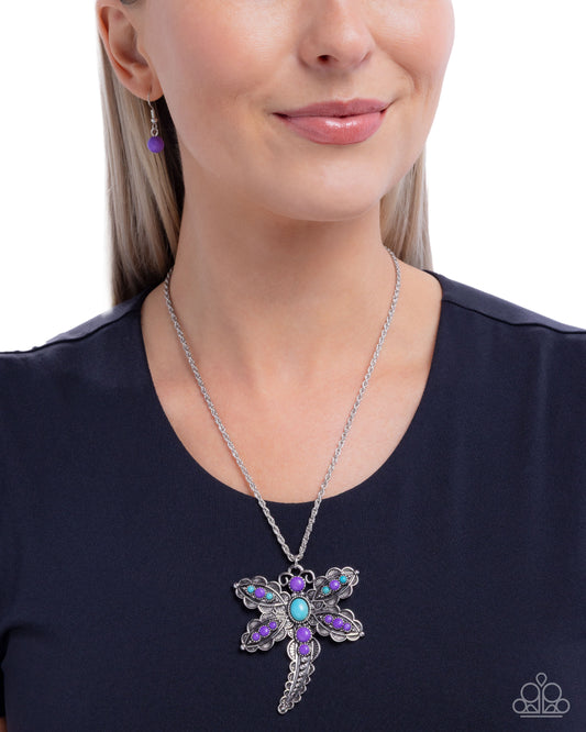 Woman wearing a silver necklace with a colorful pendant on a white background