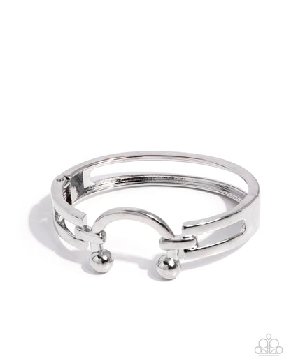 Silver ring with small spherical accents on a white background