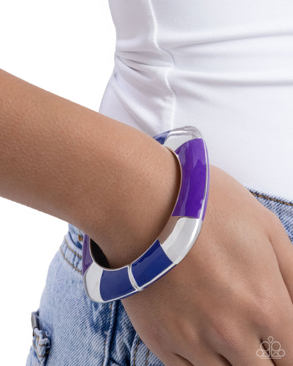 Purple and white bracelet on a wrist with a white background