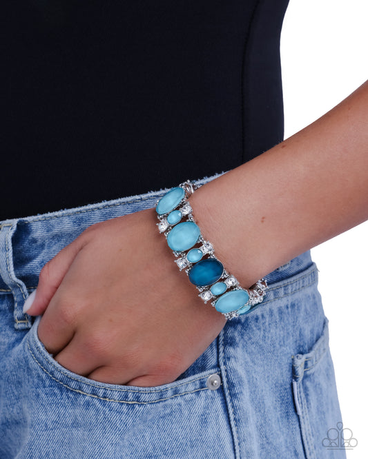 Turquoise bracelet with silver accents on a wrist against a black and white background