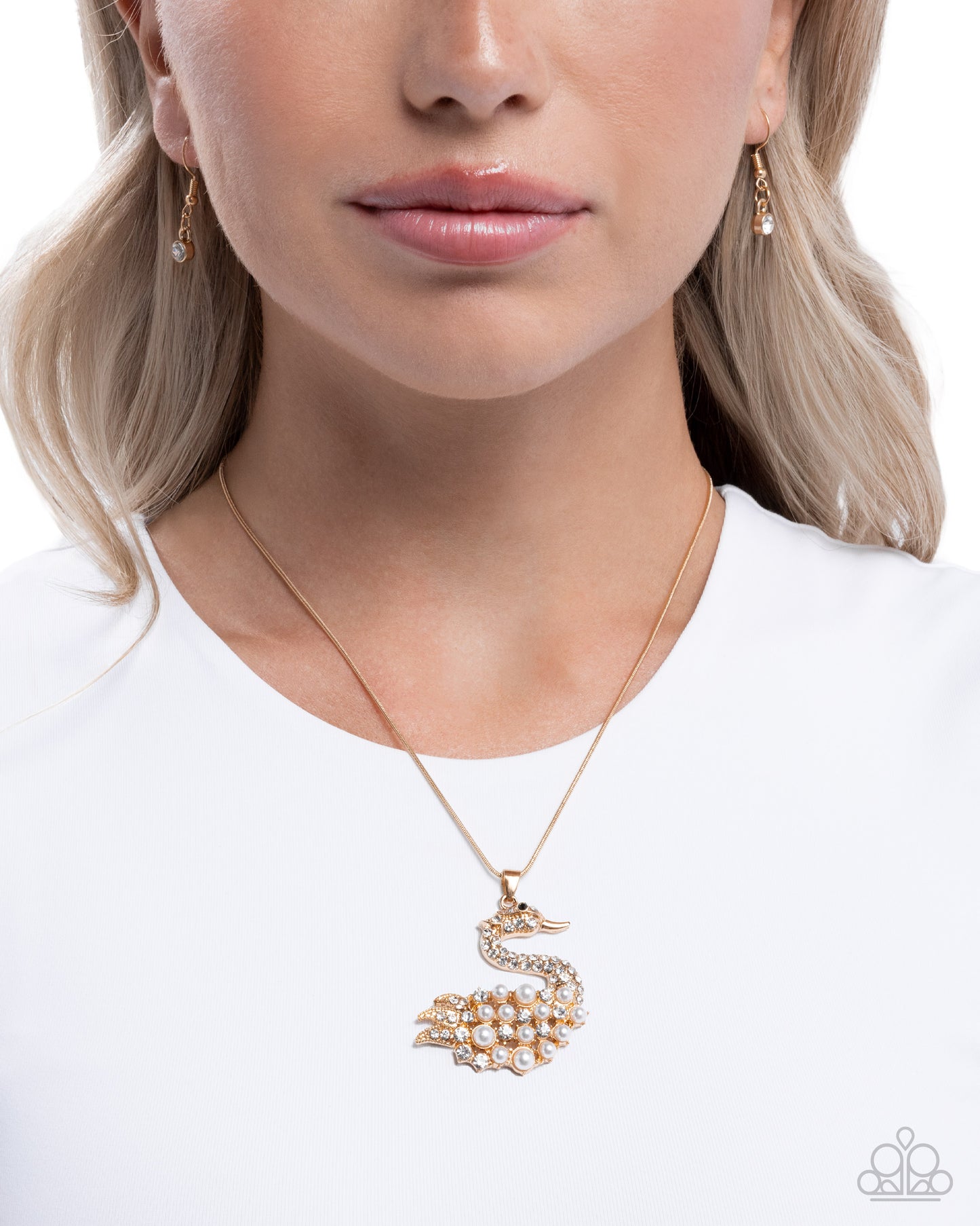 Gold swan necklace worn by a model on a white background
