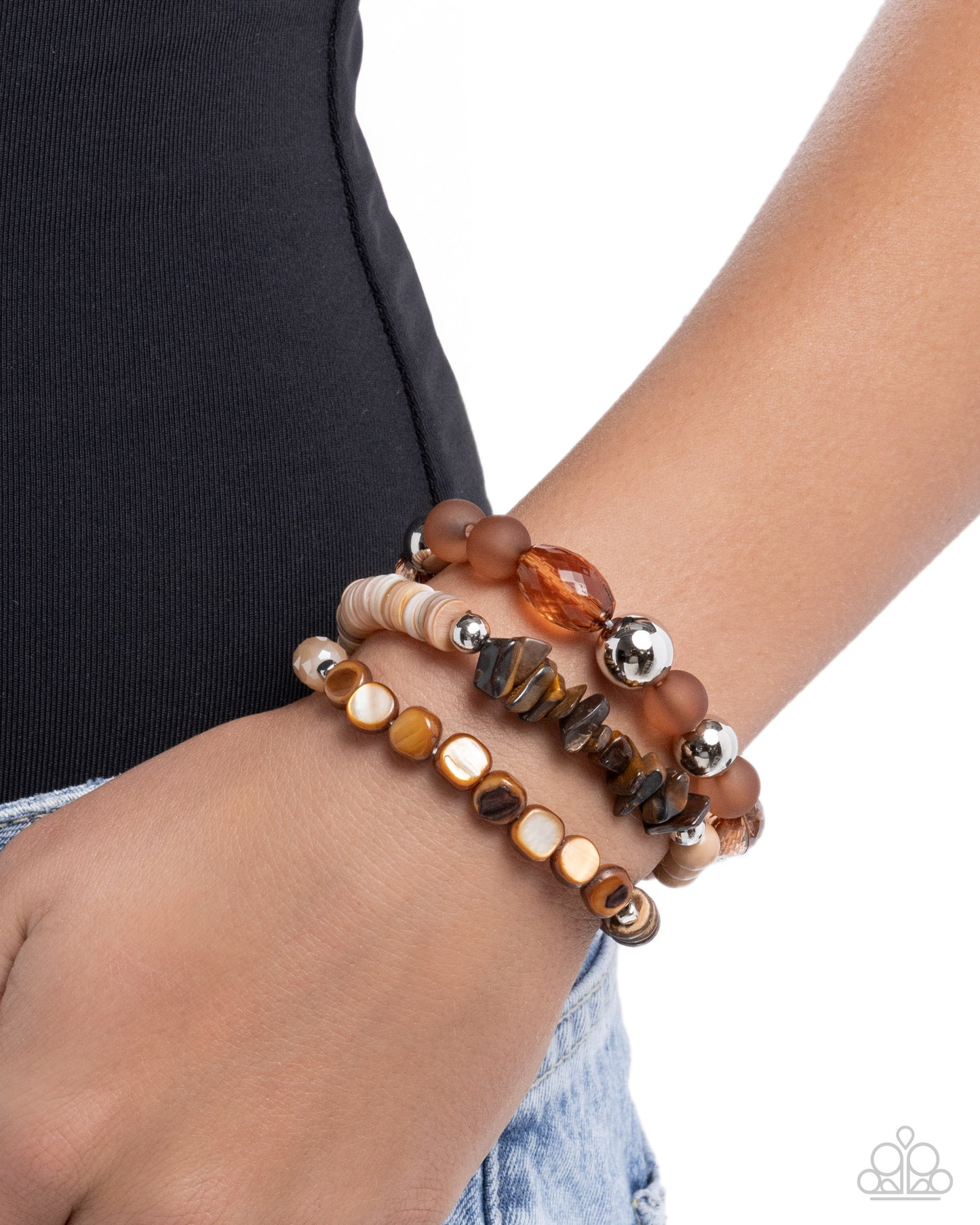 Stack of beaded bracelets on a wrist with a plain background