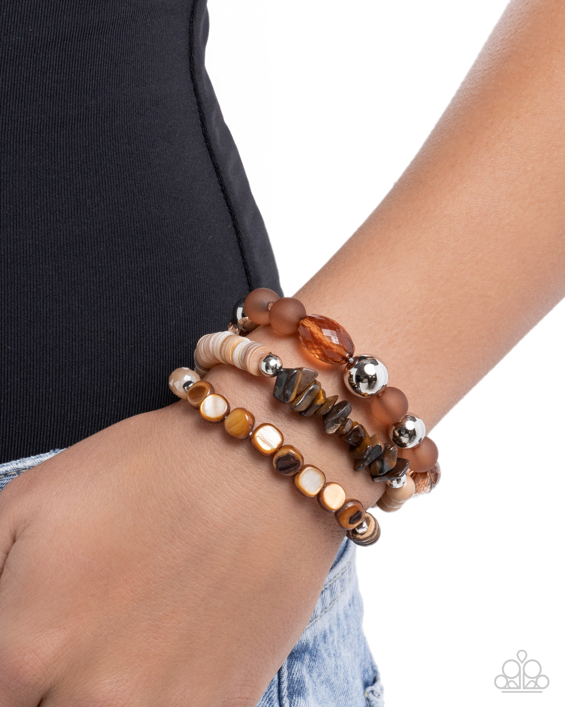 Stack of beaded bracelets on a wrist with a plain background