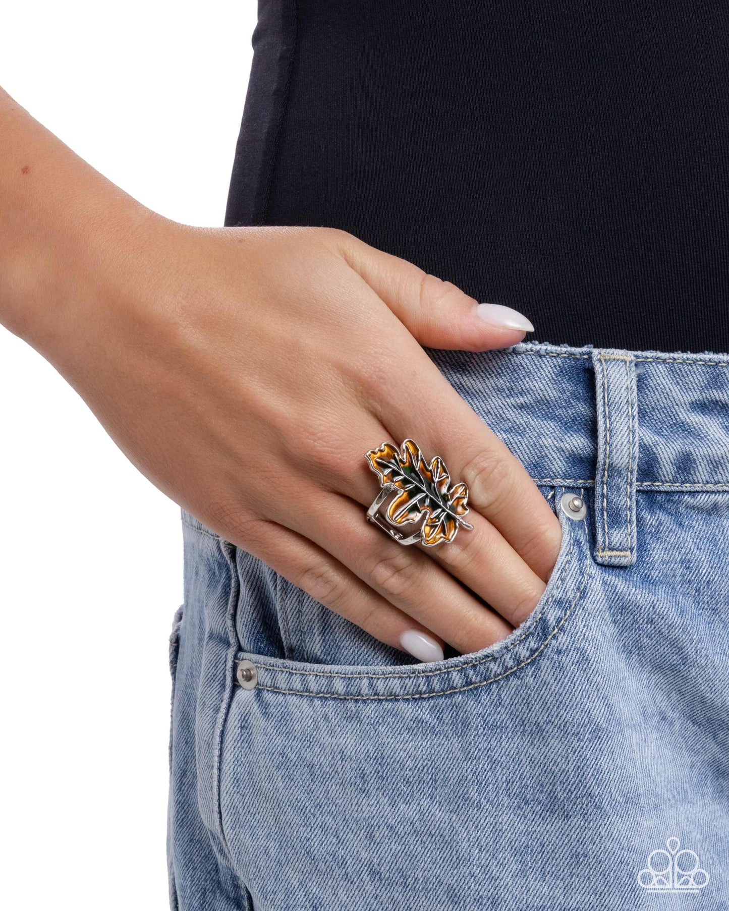 Hand wearing a decorative ring on a plain background