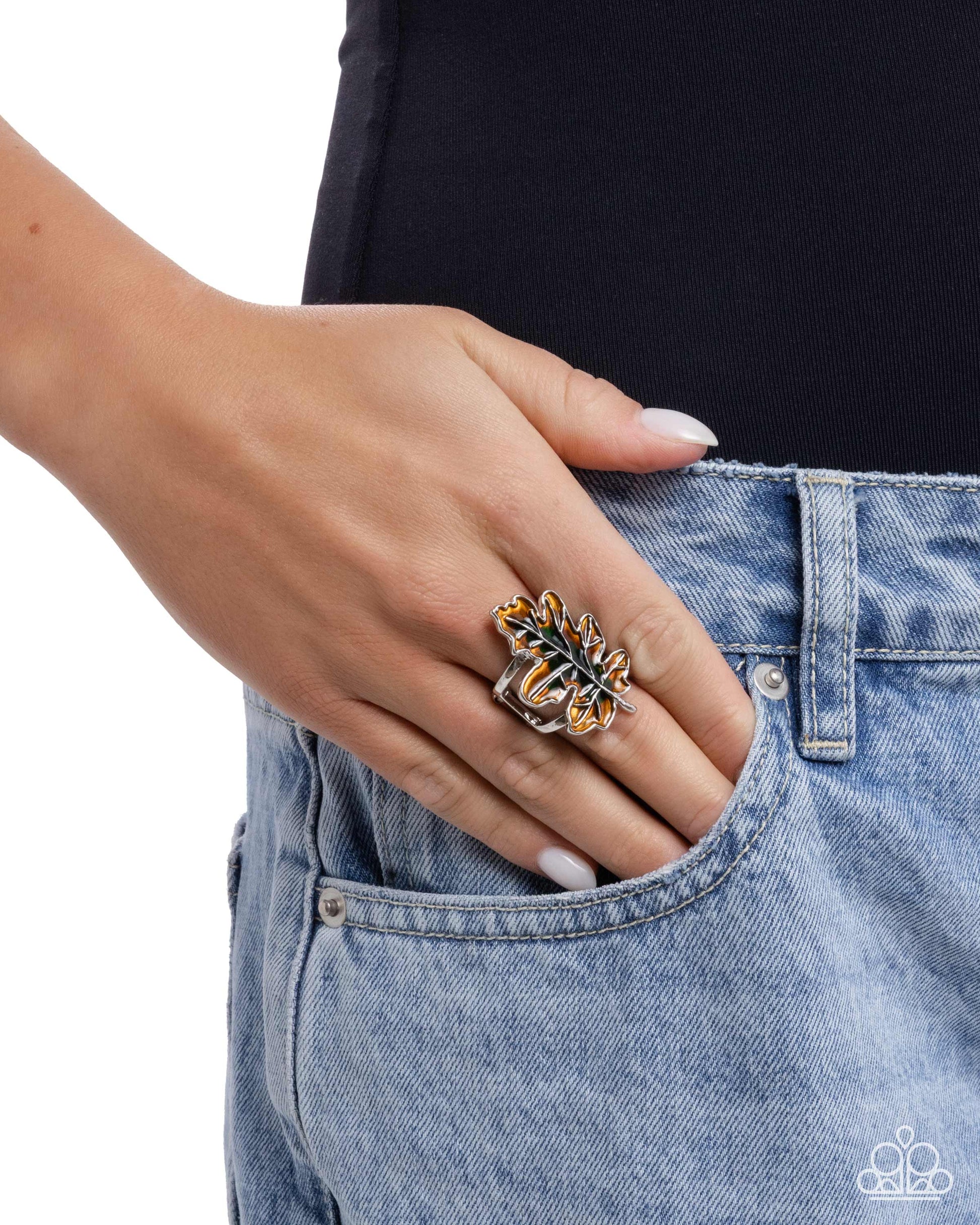 Hand wearing a decorative ring on a plain background