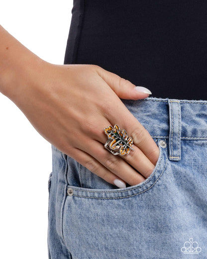 Hand wearing a decorative ring on a plain background