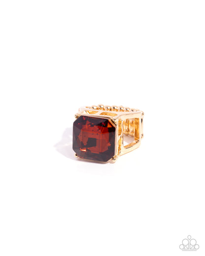 Gold ring with a large red gemstone on a white background