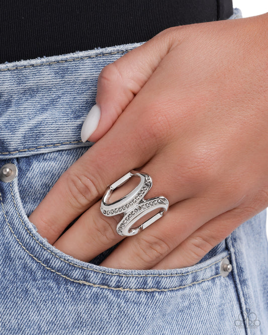 Silver ring on a finger with denim background