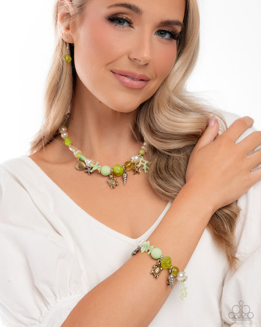 Woman wearing a green beaded necklace and bracelet on a white background