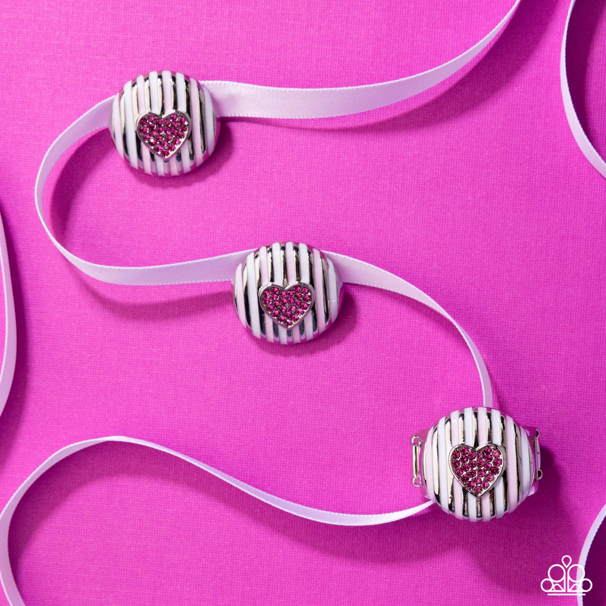 Striped hair ties with heart-shaped rhinestones on a pink background