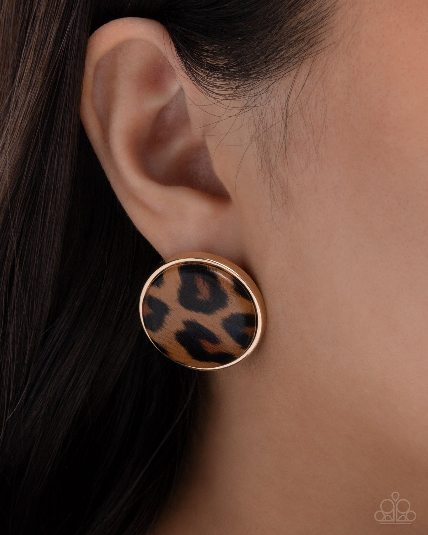 Leopard print earring on a model's ear with a neutral background