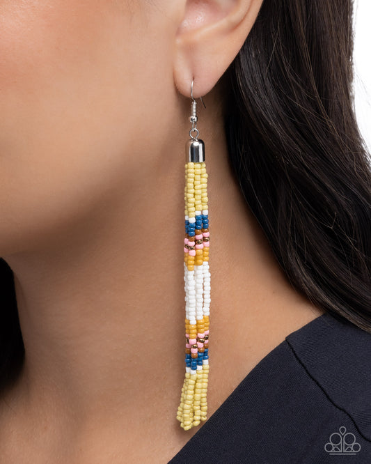 Colorful beaded earring worn by a person with dark hair.