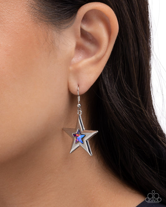 Star-shaped earring worn by a person with dark hair.