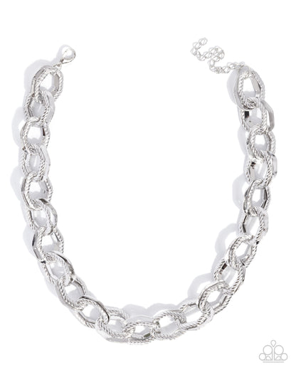 A silver-toned chunky chain link necklace with a twisted rope texture, displayed on a clean white background.